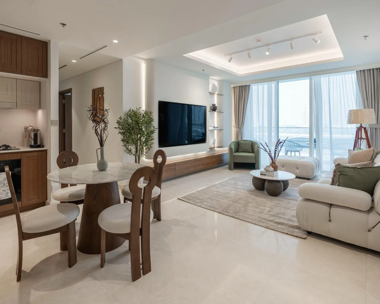 Open-plan living and dining room in Palace Emaar Beachfront with marble dining table, bouclé sofa and sea view — furnished by Aziza Home