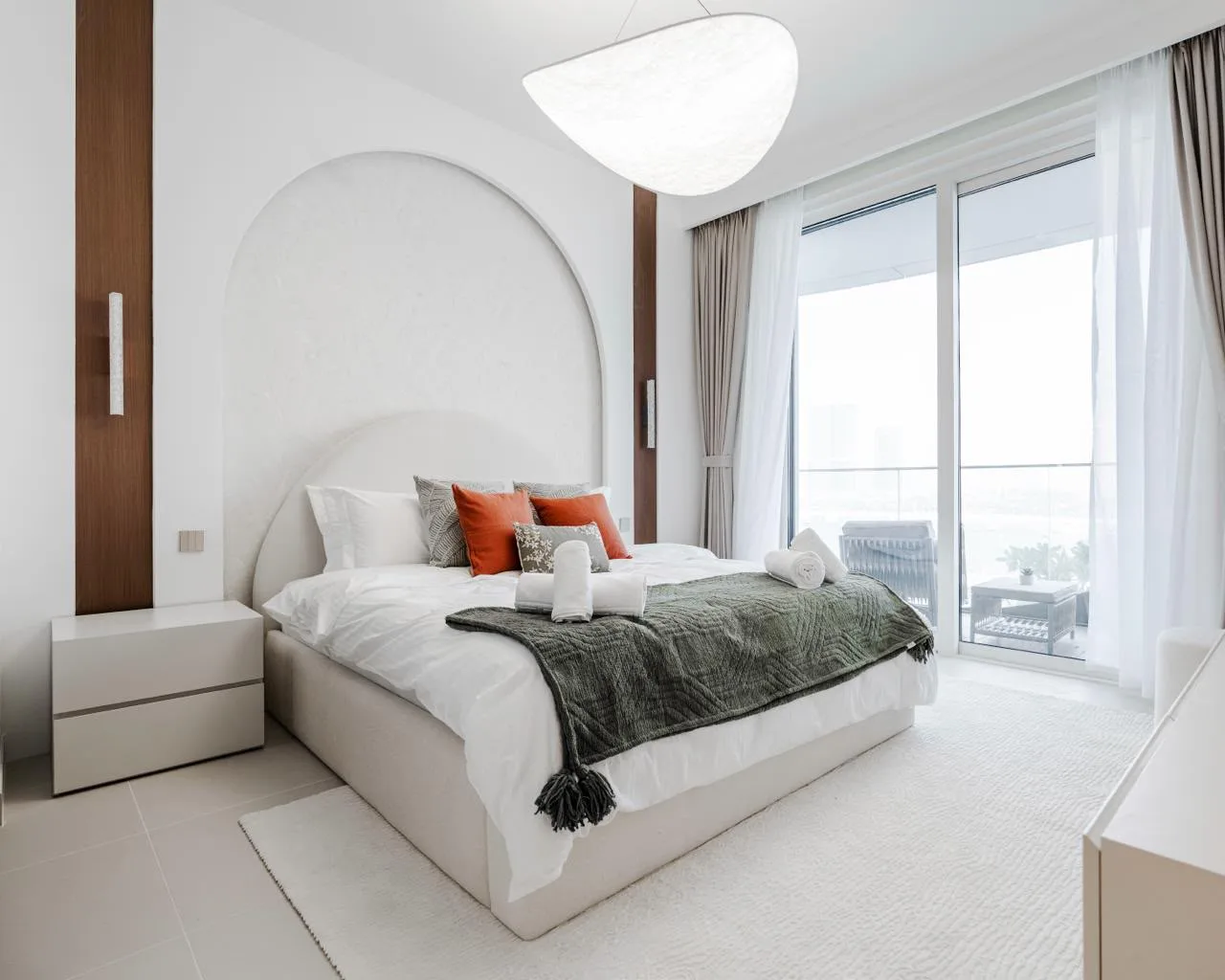 Bedroom in Palace Emaar Beachfront with arched plaster feature wall, walnut sconce piers and terracotta accent cushions