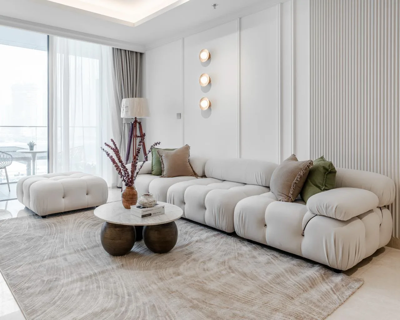Ivory modular bouclé sofa with marble coffee table and panelled feature wall in Palace Emaar Beachfront living room