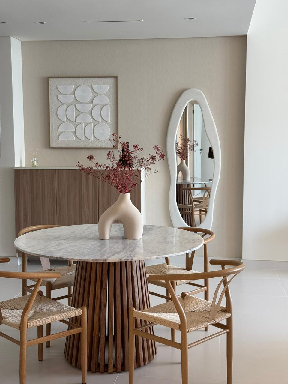 Elegant Dining Experience - Organic forms meet minimalist design with a stunning marble table and natural wood accents featuring Japandi style interior design by Aziza Home